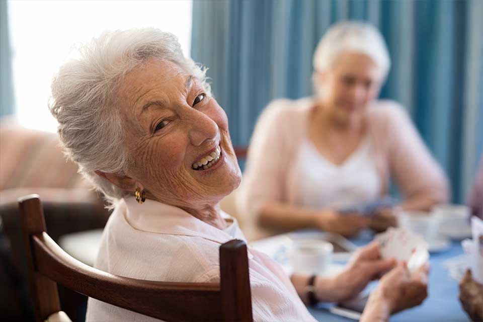 老年妇女在老年生活设施中打牌。