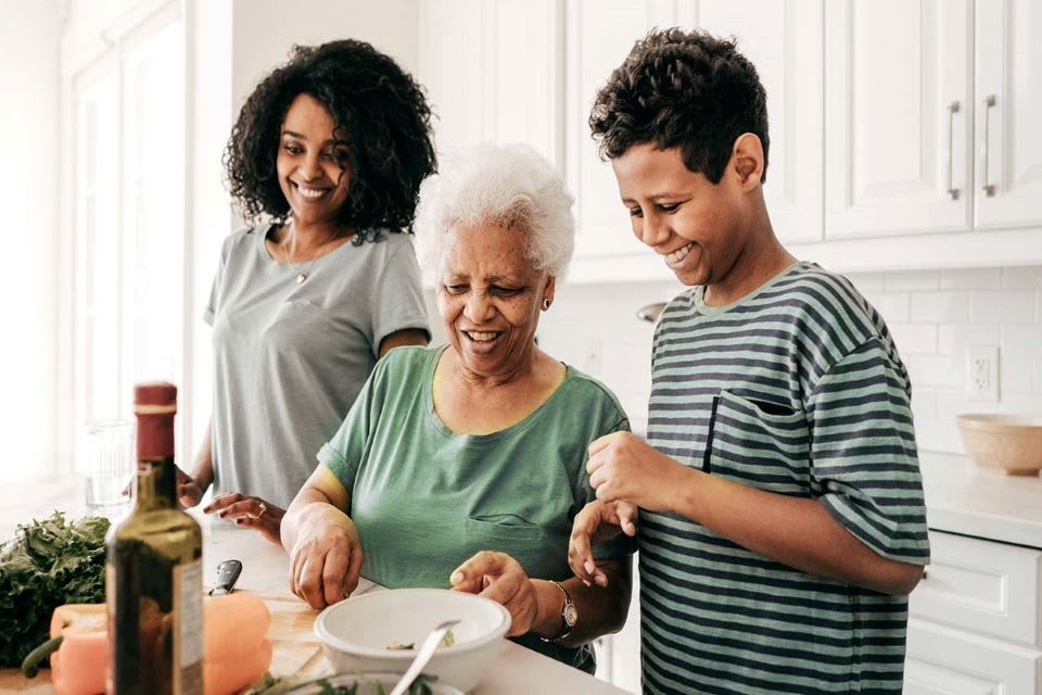 一位老年妇女和她的家人一起做饭。