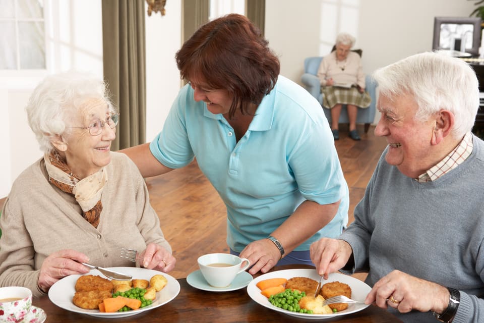一位男人和女人吃饭时微笑的生活辅助设施比较有营养的套餐。